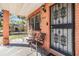 Inviting front porch with seating, brick columns, and secure iron door, offering a welcoming entrance at 2410 E Palifox St, Tampa, FL 33610