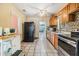 Well-lit kitchen featuring wooden cabinets, tile flooring, and modern appliances at 2410 E Palifox St, Tampa, FL 33610