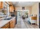 Charming kitchen with wood cabinets, tile floors, and a view into the dining area at 2410 E Palifox St, Tampa, FL 33610
