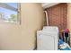 Laundry room features window, dryer, and exposed brick at 2410 E Palifox St, Tampa, FL 33610