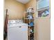 Functional laundry room with a washing machine, storage shelves, and a window for natural light at 2410 E Palifox St, Tampa, FL 33610