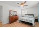 Bright bedroom features a ceiling fan, wood floors, and dresser with large mirror at 2523 Blackwood Cir, Clearwater, FL 33763