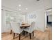 Bright dining room featuring a round table with white chairs, light wood floors, and modern lighting at 2523 Blackwood Cir, Clearwater, FL 33763