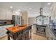 Well lit kitchen showcasing stainless steel appliances, tiled floor, and a central butcher block island at 2903 Oak Crest Dr, Plant City, FL 33565