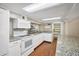 White kitchen with granite countertops, bright lighting, and hardwood floors at 2903 Oak Crest Dr, Plant City, FL 33565