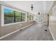 Inviting sunroom with large windows, wood paneling, ceiling fans and light gray vinyl plank flooring at 2903 Oak Crest Dr, Plant City, FL 33565