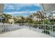 White balcony offering views of a lush neighborhood with palm trees and blue skies at 311 Poinsettia Rd, Anna Maria, FL 34216