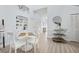 Bright dining area with white furnishings, light wood floors, and modern decor and a serving bar at 311 Poinsettia Rd, Anna Maria, FL 34216