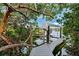 Dock view surrounded by lush foliage and calm waters under a sunny sky at 311 Poinsettia Rd, Anna Maria, FL 34216