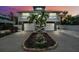 Charming two-story coastal home with dual garages, balcony, stone accents, palm trees, and a well-kept lawn at 311 Poinsettia Rd, Anna Maria, FL 34216