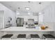 Bright kitchen featuring stainless steel appliances, white cabinets, mosaic tile backsplash, quartz countertops and pendant lights at 311 Poinsettia Rd, Anna Maria, FL 34216