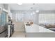 Bright kitchen featuring stainless steel appliances, white cabinets, mosaic tile backsplash and quartz countertops at 311 Poinsettia Rd, Anna Maria, FL 34216