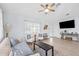 Bright living room with modern furniture, stylish decor, large windows, and a ceiling fan at 311 Poinsettia Rd, Anna Maria, FL 34216