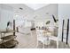Open-concept living space featuring stylish furnishings, light wood floors, and a modern kitchen with a quartz breakfast bar at 311 Poinsettia Rd, Anna Maria, FL 34216