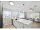 Open-concept living space featuring stylish furnishings, light wood floors, and a modern kitchen with a quartz breakfast bar at 311 Poinsettia Rd, Anna Maria, FL 34216