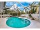 Enjoy the outdoors with this screened-in pool, surrounded by lush landscaping and a bright blue sky at 311 Poinsettia Rd, Anna Maria, FL 34216
