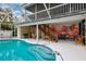 Screened-in pool with Anna Maria Island mural, seating, stairs, outdoor grill and tropical views at 311 Poinsettia Rd, Anna Maria, FL 34216