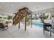 Outdoor living space features a covered patio, pool, lounge chairs, hammock, stairs and room for grilling at 311 Poinsettia Rd, Anna Maria, FL 34216