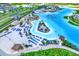 Aerial view of lagoon with beach areas, lounge chairs, tiki huts, restaurants, and a water slide at 31879 Treasure Dock Isle, Wesley Chapel, FL 33545