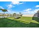 Landscaped backyard featuring a green lawn, view of a pond, and beach chairs at 31879 Treasure Dock Isle, Wesley Chapel, FL 33545