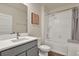 Well-lit bathroom with a single sink vanity, shower over tub and neutral color scheme at 31879 Treasure Dock Isle, Wesley Chapel, FL 33545