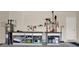 Organized garage featuring two workbenches with shelving for storage and a variety of tools at 31879 Treasure Dock Isle, Wesley Chapel, FL 33545