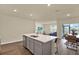 Bright, open kitchen with stainless appliances, island seating and view to living and dining areas at 31879 Treasure Dock Isle, Wesley Chapel, FL 33545