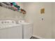 Functional laundry room featuring a washer and dryer with wire shelving at 31879 Treasure Dock Isle, Wesley Chapel, FL 33545