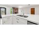 Close-up of kitchen island featuring white cabinets, stainless steel sink and faucet, and quartz countertops at 360 22Nd Ne Ave, St Petersburg, FL 33704