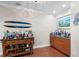 Bar area complete with a surfboard, wood floors, and built in cabinets at 6327 Sunset Bay Cir, Apollo Beach, FL 33572
