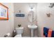 Powder room featuring a pedestal sink, toilet, and charming beach-themed decorations at 6327 Sunset Bay Cir, Apollo Beach, FL 33572