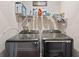 Laundry room with modern, dark-colored washer and dryer, plus shelving for supplies at 6327 Sunset Bay Cir, Apollo Beach, FL 33572