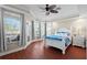Bedroom with wood floors, a ceiling fan, and access to a balcony at 6327 Sunset Bay Cir, Apollo Beach, FL 33572