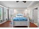 Bright main bedroom featuring hardwood floors, white trim and a large bed with blue accents at 6327 Sunset Bay Cir, Apollo Beach, FL 33572