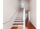 Staircase with a white railing and beautifully patterned tile risers, complemented by wood flooring on the landing at 6327 Sunset Bay Cir, Apollo Beach, FL 33572
