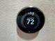 A smart thermostat on a textured wall displays the current temperature and settings at 6327 Sunset Bay Cir, Apollo Beach, FL 33572