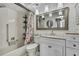 Bathroom featuring a shower-tub combo, pendant lights, and a large framed mirror at 6395 Pinestand Ct, Spring Hill, FL 34606