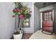 Charming entry with red door, gray siding, and blooming bougainvillea at 6395 Pinestand Ct, Spring Hill, FL 34606