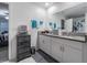 Bright bathroom with a double sink, granite countertop, drawers, and a decorative chest for storage at 6494 Beverly Hills Dr, Zephyrhills, FL 33541