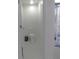 This clean, all-white bathroom features a toilet, trash can, and partial view of shower at 6494 Beverly Hills Dr, Zephyrhills, FL 33541