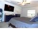 This bedroom features a television, a ceiling fan, and a window with light coming in at 6494 Beverly Hills Dr, Zephyrhills, FL 33541