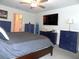 This bedroom features a ceiling fan and television, plus a door to the bathroom at 6494 Beverly Hills Dr, Zephyrhills, FL 33541