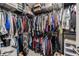Walk-in closet with metal shelving, fully stocked with lots of clothing items, and storage boxes at 6494 Beverly Hills Dr, Zephyrhills, FL 33541