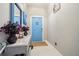 A modern entryway with a stylish table, blue door, and contemporary decor at 6494 Beverly Hills Dr, Zephyrhills, FL 33541