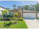 Charming single-story home with manicured lawn, lush landscaping, and attached two-car garage at 6494 Beverly Hills Dr, Zephyrhills, FL 33541