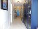 Bright hallway with display cabinets, tiled floors, and a view of the front door at 6494 Beverly Hills Dr, Zephyrhills, FL 33541