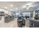 Open-concept living room with white cabinets, granite counters, stainless appliances, dining area, and comfortable gray couches at 6494 Beverly Hills Dr, Zephyrhills, FL 33541