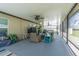 Large screened patio featuring multiple ceiling fans, ample seating, and durable flooring at 6494 Beverly Hills Dr, Zephyrhills, FL 33541