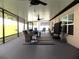 Spacious screened patio offering a relaxing outdoor living area with ceiling fans, seating, and durable flooring at 6494 Beverly Hills Dr, Zephyrhills, FL 33541