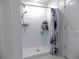 The walk-in shower features white tile and modern fixtures, plus built in shelving at 6494 Beverly Hills Dr, Zephyrhills, FL 33541